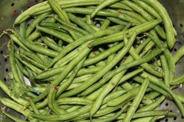 Onun arka planında yeşil sebze var..