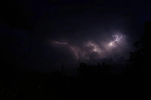 Blitze und Gewitter in der Nacht bewölkt. Blitze funkeln durch die Wolken. Nachtschießen. — Stockfoto