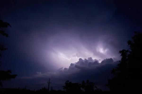 Blitze und Gewitter in der Nacht bewölkt. Blitze funkeln durch die Wolken. Nachtschießen. — Stockfoto