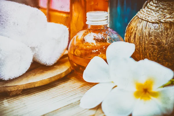 Pastel Spa oils in bottles on wooden table and nature background