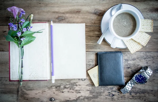 cup of coffee on rustic wooden table with open books