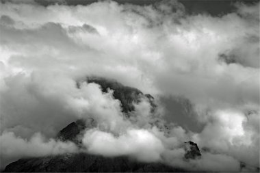 Bulutlarla gizlenmiş bir dağ zirvesi manzarası