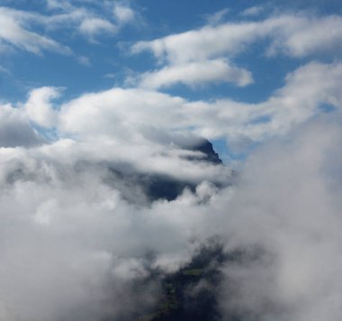 Bulutlarla gizlenmiş bir dağ zirvesi manzarası