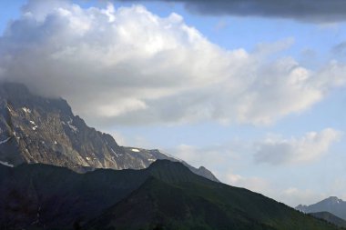 bir dağ yamacı ve bulutlar