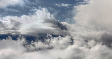 Bulutlarla kaplı dağ zirvesi manzarası