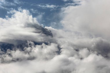 Bulutlarla kaplı dağ zirvesi manzarası