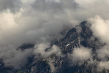 Bulutlarla kaplı bir dağın manzarası