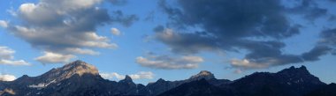 Bir dağ sırasının panoramik görüntüsü ve akşamları bulutlar