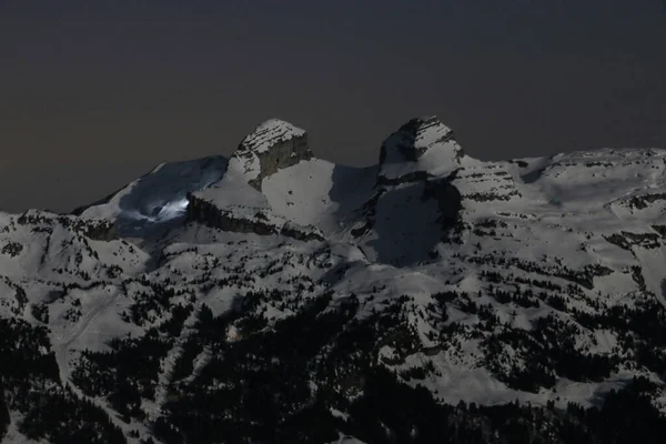 two snow covered mountain peaks at night