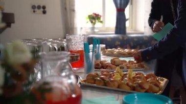 Yemek masası parti kutlaması için hazırlandı, kanepeler, atıştırmalıklar ve diğer lezzetli aperatiflerle dolu tepsiler. Bulanık davetli misafirler açık büfe menüsü, doğum günü için ziyafet masası