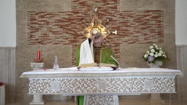 CASSINO, ITALY - OCTOBER 18, 2020: Italian pastor holding religious ceremony in the local church of Cassino city, faithful priest reading Holy Scripture, praying and drinking sacred wine from gold — Stock Video