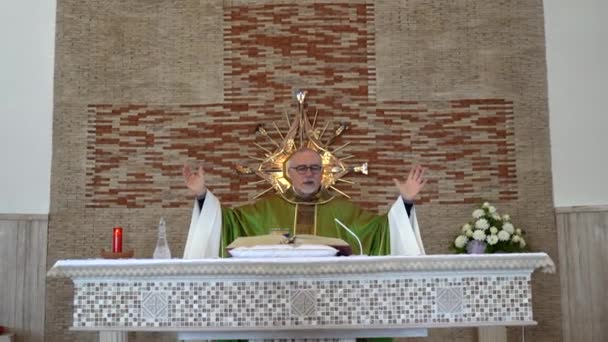 CASSINO, ITALIË - OKTOBER 18, 2020: Priester van middelbare leeftijd van de provinciale Italiaanse kerk gekleed in heilige groene soutane met liturgische mis op zondag naast het altaar van de tempel en het lezen van Heilige — Stockvideo