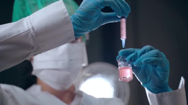 Лабораторные эксперименты в научно-исследовательском центре, концентрированные женщины-учёные, работающие с химическими элементами и растворами, разрабатывающими эффективную вакцину против ковида-19. Химик вливает — стоковое видео