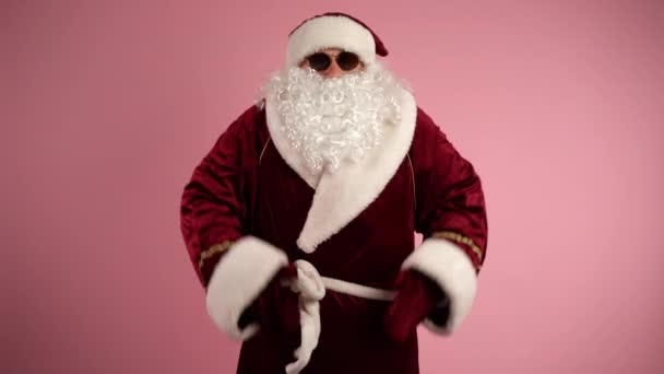 Överraskad jultomten med långt vitt skägg kasta armar brett på isolerade rosa bakgrund och titta på kameran. Oigenkännlig man i traditionella tomtekläder som visar känslor. Jultomten — Stockvideo