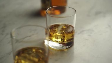Golden whiskey with ice cubes in crystal clear glasses on marble table, delicious brandy drink for holidays and celebration. Alcohol whisky in local pub, ancient amber beverage