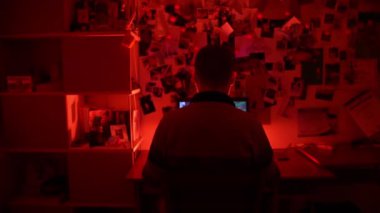 Erkek profesyonel oyuncunun gece gündüz karanlık odada oturup kırmızı neon ışıkla aydınlatılması ve güçlü PC 'de RPG siber oyunlar oynaması. Sanal uzayda sanal oyun şampiyonluğu, teknoloji