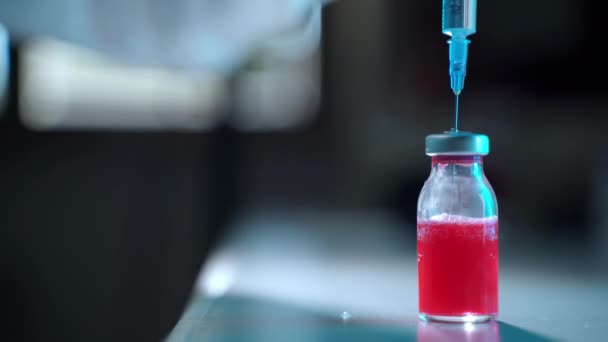 Izolovaná lahvička s červeným roztokem na sterilním stole ve výzkumné laboratoři, chemický roztok vyvinutý pro očkování osob. Připravená lahvička s vakcínou pro nemocniční pacienty, mikrobiologii a — Stock video