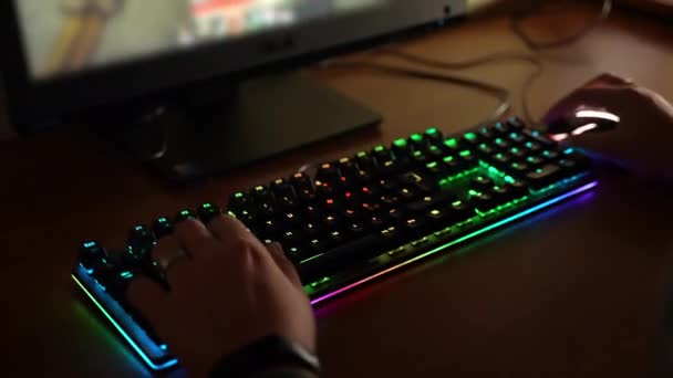 Profesyonel oyuncular evde online video oyunları oynayıp sanal oyuncular ile sanal turnuvalara katılıyorlar. Arkadan ışıklandırmalı klavye kullanan adam renkli tuşlara basıyor. Klavye — Stok video