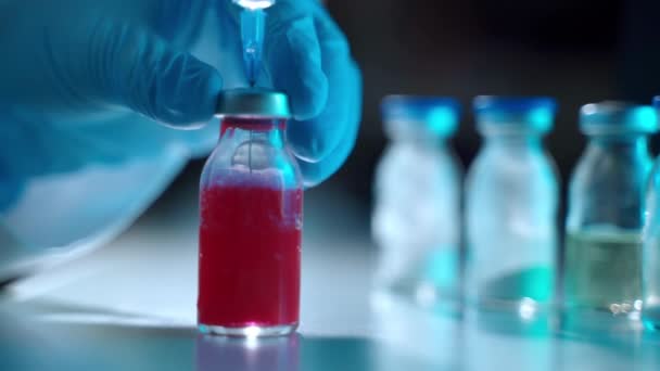 Investigador llenando jeringa estéril con solución roja de ampolla transparente, análisis médico, investigaciones de laboratorio y desarrollo de vacunas — Vídeos de Stock