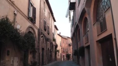 Tuscania köyündeki resim gibi ve atmosferik kaldırım taşı gibi dar bir sokak, farklı mimari çağların dış cephesine sahip görkemli turuncu ve kahverengi binalar. Geleneksel İtalyan kemerli