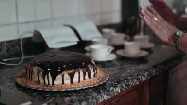 Tasty homemade chocolate cake on kitchen table, sweet dessert with chocolate glaze prepared for celebrating party. Traditional biscuits cake and cups of coffee for holidays. Pastry and bakery concept — Stock Video
