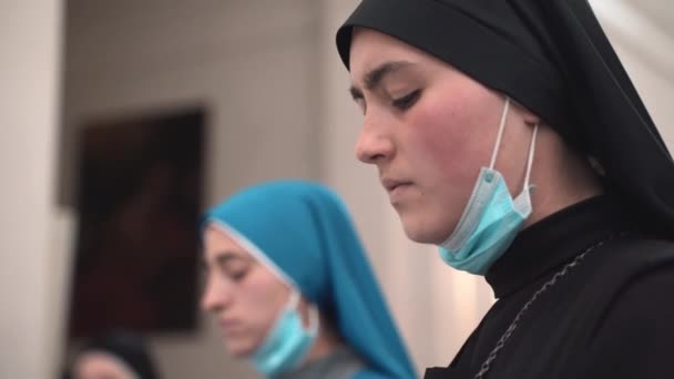 TUSCANIA, VITERBO - 31 oktober 2020: Kyrkliga nunnor som sjunger i kyrkan under bröllopsmässa i byn Viterbo i Toscana. Lydiga religiösa systrar prisa och tigga Gud för — Stockvideo