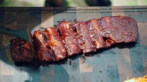 Chef corte jugoso lomo de cerdo asado costillas con salsa picante en rebanadas en tablero de cocina de madera hecha a mano, apetecible parrilla de carne para gourmets. Salsa picante roja preparada para parrilla de cerdo, hecha a mano — Vídeos de Stock