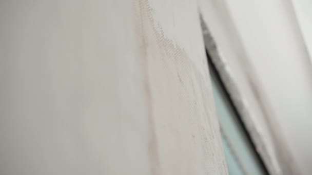 Close-up van de gereconstrueerde muur op de bouwplaats in nieuw aangekocht appartement, bouwmeester putten en uitlijnen muur met metalen spatel en afwerking spackling pasta oplossing. Proces van — Stockvideo