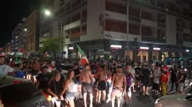 ROME, ITALY - 6 Temmuz 2021: İtalyan spor takımının EURO 2020 'nin yarı finalinde İspanya' ya karşı kazandığı duygusal zafer, fanatik adamlar Roma caddelerinde maç zaferini kutluyorlar ve ellerinde bayraklar sallıyorlar.