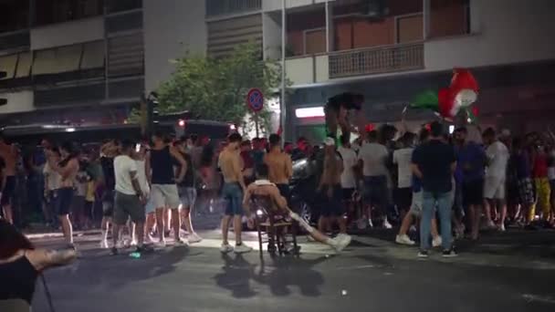 ROMA, ITALIA - 6 DE JULIO DE 2021: Fanáticos gamberros del fútbol italiano celebrando la victoria del equipo deportivo italiano en el partido de semifinales en EURO 2020, chicos borrachos subiendo a los techos de los coches que pasan y bailando — Vídeo de stock