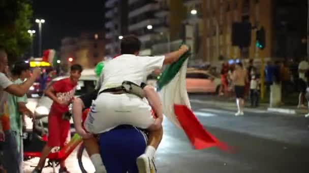 ROME, ITALIEN - 6 juli 2021: Emotionell seger för det italienska idrottslaget i semifinalen i EURO 2020 mot Spanien, fanatiska killar som firar matchseger på romerska gatublockerande gator och vinkar — Stockvideo