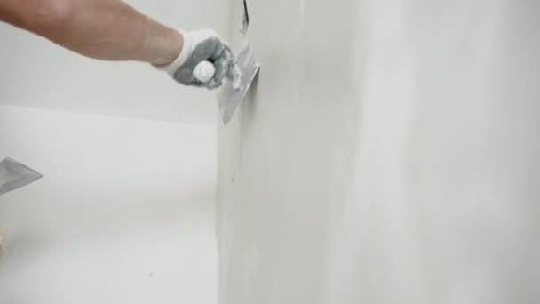 Ingegnere in guanti protettivi spackling wall con spatola metallica, livellamento uomo e allineamento superficie della parete con finitura bianca pasta intonaco soluzione. Pareti processo di imbiancamento, riparazione — Video Stock