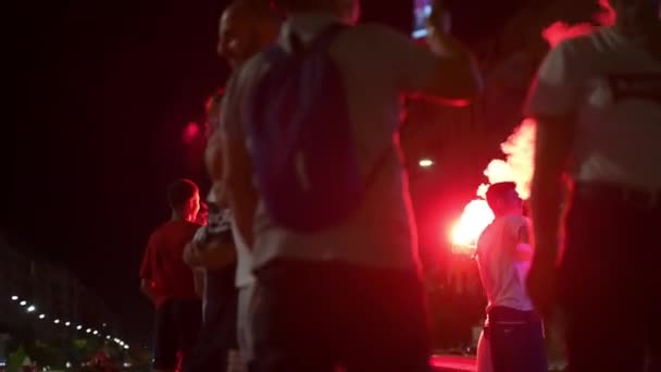 ROMA, ITÁLIA - JULHO 6, 2021: Apresentações de protesto de rua noturna de torcedores de futebol queimando foguetes de fumaça e mostrando felicidade após a vitória da equipe esportiva italiana na semifinal EURO 2020. Sinal de fumaça vermelho em — Vídeo de Stock