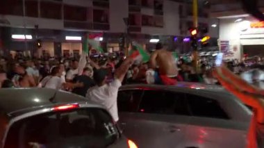 ROME, ITALY - 6 HAZİRAN 2021: Yarı final zaferini kutlayan öfkeli İtalyan futbol taraftarları Roma sokaklarında vandalizm yapıyorlar, çılgın adam tişörtsüz arabanın çatısında oturuyor ve bayrak sallıyor, başka bir adam