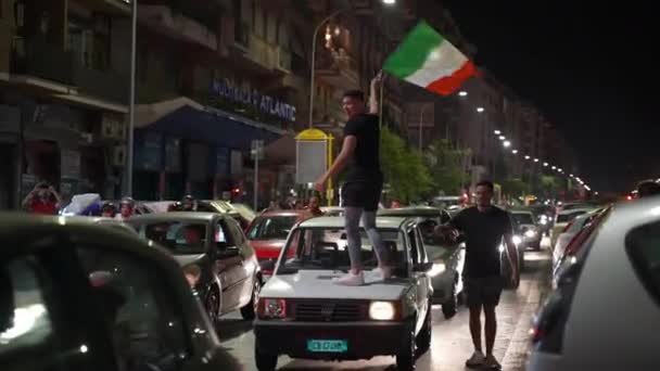 ROME, ITALY - JULY 6, 2021: Emotional victory of Italian sport team in semi-final of UEFA EURO 2020 against Spain, fans celebrating match victory on Roman street blocking roads and waving flags — Stock Video