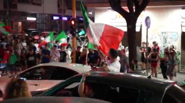 Roma, İtalya - 11 Temmuz 2021: İngiltere 'ye karşı oynanan duygusal futbol maçından sonra Roma sokaklarında bayraklarını sallayan mutlu İtalyan taraftarlar kalabalığı. İnsanlar bağırıyor, dans ediyor, içki içiyor, İtalya