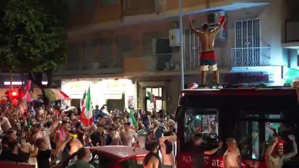 ΡΩΜΗ, ΙΤΑΛΙΑ - 11 ΙΟΥΛΙΟΥ 2021: Μεθυσμένος δρόμος Ιταλός χούλιγκαν στην οροφή των λεωφορείων ουρλιάζοντας και σηκώνοντας τα χέρια ψηλά, τύπος που υποστηρίζει την ιταλική αθλητική ομάδα με πλήθος μετά τη νίκη στο UEFA EURO 2020. Οδός — Αρχείο Βίντεο
