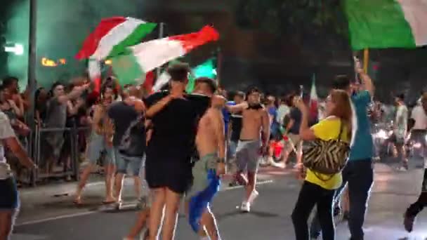 ROME, OLASZORSZÁG - JÚLIUS 11, 2021: Olasz rajongók lengő zászlókkal elállják az utakat a labdarúgó csapat UEFA EURO 2020-as győzelme után, boldog utcai rajongók táncolnak az úton, ugrálnak és kiabálnak örömükben — Stock videók