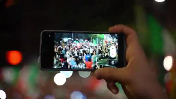 ROME, ITALIEN - 11 juli 2021: Italienska fan inspelning mästerskap seger fest på smartphone, folkmassa på gatorna i Rom viftande flaggor och skrika stödja sitt nationella idrottslag — Stockvideo