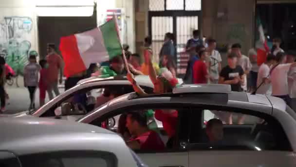 ROME, ITALIEN - 11 juli 2021: Italienska fans firar segern för idrottslaget i den slutliga fotbollsmatchen EURO 2020, killar blockerar vägar, viftar med flaggor, hoppar och skriker. Gatufans och supportrar — Stockvideo