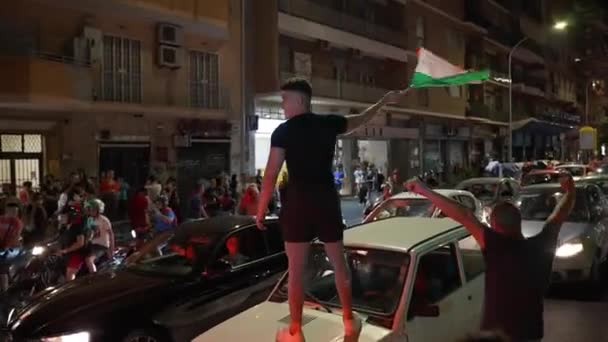 ROMA, ITALIA - 11 DE JULIO DE 2021: Abanico italiano parado en el techo del coche y ondeando la bandera, aficionados al fútbol celebrando la victoria en la final de la UEFA EURO 2020, multitud de aficionados italianos en las calles romanas después de la — Vídeo de stock