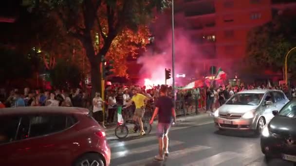 罗马，意大利- 2021年7月11日：在欧洲足球协会2020年欧洲杯结束后，意大利街头愤怒的歌迷们聚集在一起，举着旗帜挡住道路，欢快地跳、唱、跳和喊着。燃烧的风扇 — 图库视频影像
