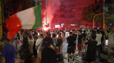 ROME, ITALY - 11 Temmuz 2021: UEFA EURO 2020 'den sonra Roma sokaklarında öfkeli İtalyan hayranlar, bayraklı kalabalık yolları kapatıyor, zıplıyor, şarkı söylüyor, dans ediyor, neşe içinde bağırıyor ve kırmızı yanıyor