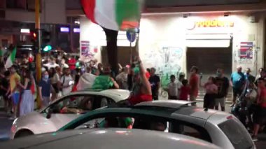 ROME, ITALY - 11 Temmuz 2021: İtalyan taraftarlar EURO 2020 final maçında spor takımının zaferini kutluyor, erkekler arabalarda yolları kapatıyor, bayraklar sallıyor, zıplıyor ve bağırıyorlar. Sokak hayranları ve