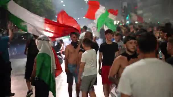 ROMA, ITÁLIA - JULHO 11, 2021: Fãs italianos comemorando a vitória da equipe esportiva no último jogo de futebol EURO 2020, caras bloqueando estradas, agitando bandeiras, pulando e gritando. Fãs de rua e apoiantes — Vídeo de Stock