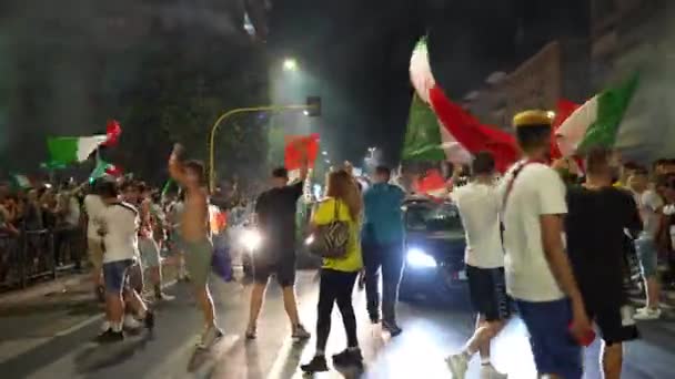 ROMA, ITALIA - 11 DE JULIO DE 2021: Aficionados italianos con banderas ondeando bloqueando carreteras tras la victoria del equipo de fútbol en la UEFA EURO 2020, felices aficionados callejeros bailando en la carretera, saltando y gritando de alegría — Vídeo de stock