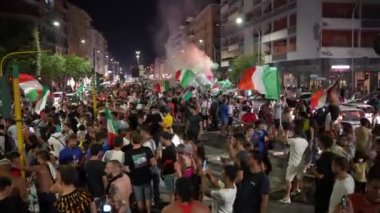 ROME, ITALY - 11 Temmuz 2021: Bir grup İtalyan taraftar UEFA EURO 2020 final maçında zaferini kutluyor, bayrakları atlayan, el kaldıran, sevinçle bağıran ve dans eden insanlar