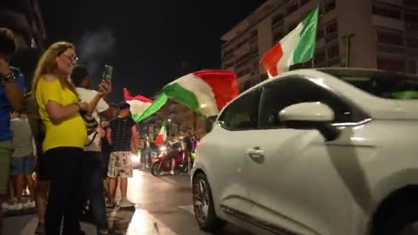 ROME, ITALIEN - 11 juli 2021: Italienska fans firar segern för idrottslaget i den slutliga fotbollsmatchen EURO 2020, killar blockerar vägar, viftar med flaggor, hoppar och skriker. Gatufans och supportrar — Stockvideo