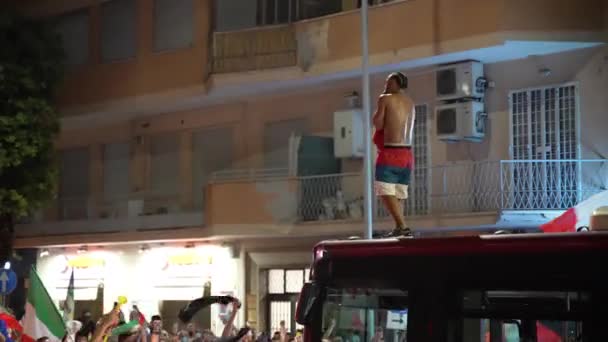ROMA, ITÁLIA - JULHO 11, 2021: Bêbado rua italiano hooligan sem T-shirt dançando e pulando no telhado do ônibus motivando multidão com mãos erguidas e gritando, italianos comemorando a vitória na UEFA EURO — Vídeo de Stock