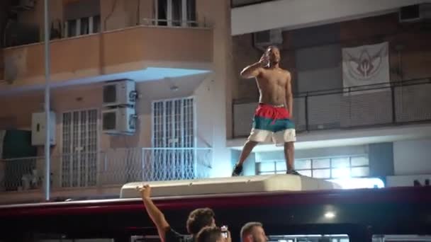 ROME, ITALIEN - 11 juli 2021: Två berusade italienska huliganer står på busstaket motiverande publik med lyfta händer och skriker för att fira seger i fotbollsmatch EURO 2020 mot England — Stockvideo